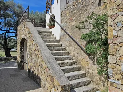 a set of stone stairs next to a stone wall at 1st floor apartment in 18th century character house in Calvi