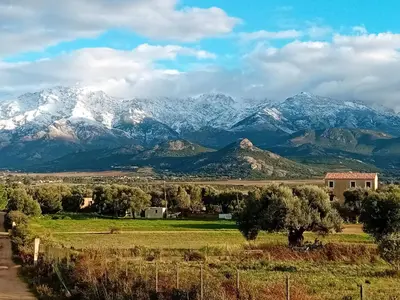 a mountain range with snow covered mountains in the distance at 1st floor apartment in 18th century character house in Calvi
