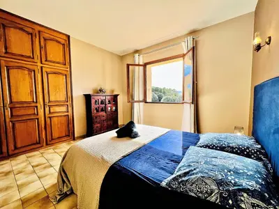 a bedroom with a bed with a cat sitting on it at CasaCampanile in Olmeto