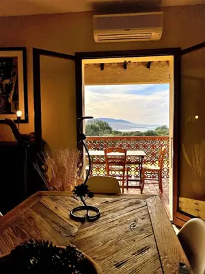 a dining room table with a view of a patio at CasaCampanile in Olmeto