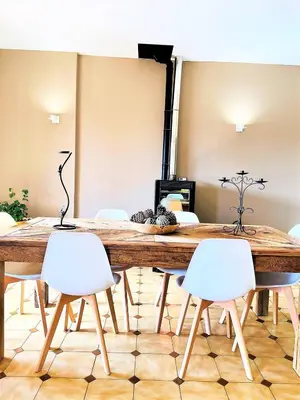 a dining room with a wooden table and white chairs at CasaCampanile in Olmeto