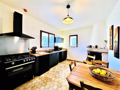 a kitchen with a table with a bowl of fruit on it at CasaCampanile in Olmeto