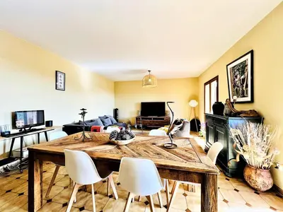 a living room with a wooden table and white chairs at CasaCampanile in Olmeto