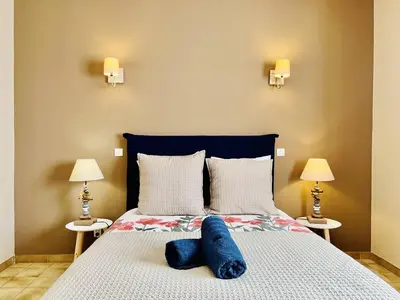 a bedroom with a bed with two blue pillows on it at CasaCampanile in Olmeto