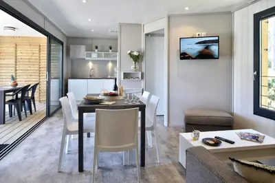 a kitchen and living room with a table and chairs at Résidence & Hotel U Livanti ECOLABEL in Propriano