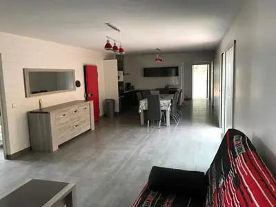 a living room with a couch and a dining room at Plain pied idéalement situé in Sainte-Lucie de Porto-Vecchio