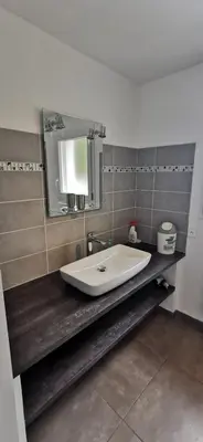 a bathroom with a sink and a mirror at Plain pied idéalement situé in Sainte-Lucie de Porto-Vecchio