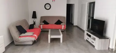 a living room with a couch and a tv at Plain pied idéalement situé in Sainte-Lucie de Porto-Vecchio