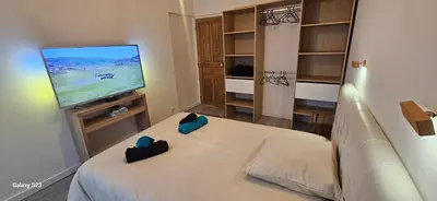 a bedroom with a bed and a flat screen tv at Maison Quenza Corse-du-Sud in Quenza