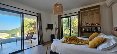 a bedroom with a bed with a yellow blanket on it at Hôtel Résidence de standing Casa Pian d'Olmo in Olmiccia