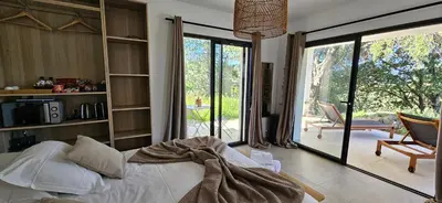 a bedroom with a bed and a large sliding glass door at Hôtel Résidence de standing Casa Pian d'Olmo in Olmiccia
