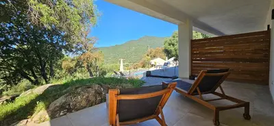 a patio with a table and chairs and a sliding glass door at Hôtel Résidence de standing Casa Pian d'Olmo in Olmiccia
