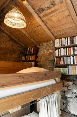 a bedroom with a bed and a book shelf with books at Relais - U Machjonu in Tolla