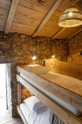 a bed in a room with a stone wall at Relais - U Machjonu in Tolla