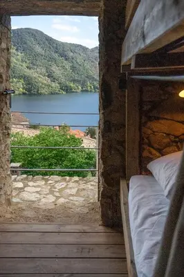 a bedroom with a view of a lake from a window at Relais - U Machjonu in Tolla