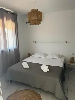 a bedroom with a bed with two towels on it at Appartement Cosy à Lecci , Porto Vecchio in Lecci