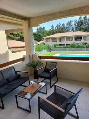 a patio with chairs and a table and a pool at Appartement Cosy à Lecci , Porto Vecchio in Lecci