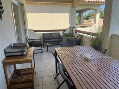 a patio with a table and chairs on a balcony at Appartement Cosy à Lecci , Porto Vecchio in Lecci