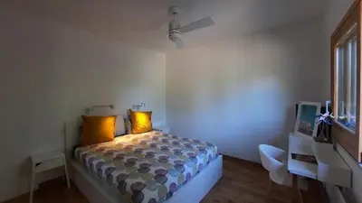 a bedroom with a bed with yellow pillows at Havre de paix à 10 minutes de la mer et 15 minutes d'Ajaccio in Appietto