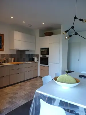 a kitchen with a white table with chairs and appliances at Havre de paix à 10 minutes de la mer et 15 minutes d'Ajaccio in Appietto
