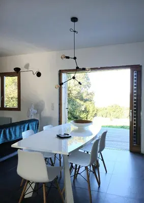 a dining room with a white table and chairs at Havre de paix à 10 minutes de la mer et 15 minutes d'Ajaccio in Appietto