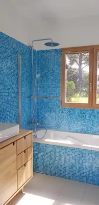 a blue tiled bathroom with a tub and a window at Havre de paix à 10 minutes de la mer et 15 minutes d'Ajaccio in Appietto