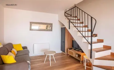 a living room with a couch and a staircase at Les Hauts de Pavellone in Porto-Vecchio