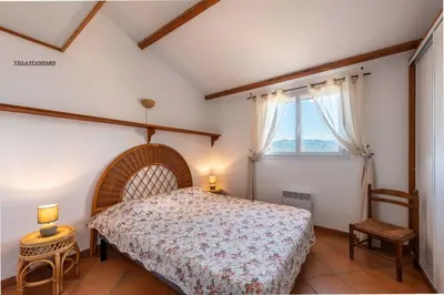 a bedroom with a bed and a window at Les Hauts de Pavellone in Porto-Vecchio