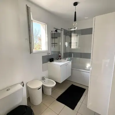 a white bathroom with a toilet and a sink at Appartement cosy avec wifi en bord de mer in Poggio-Mezzana