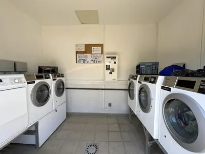 a laundry room with three washing machines in it at Appartement cosy avec wifi en bord de mer in Poggio-Mezzana