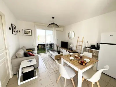 a kitchen and living room with a table and chairs at Appartement cosy avec wifi en bord de mer in Poggio-Mezzana