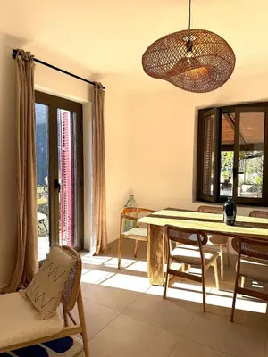 a dining room with a table and chairs and a window at Résidence Hôtelière CASA DI BABBÒ, Porto in Porto Ota