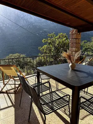 a table and chairs on a balcony with a view at Résidence Hôtelière CASA DI BABBÒ, Porto in Porto Ota