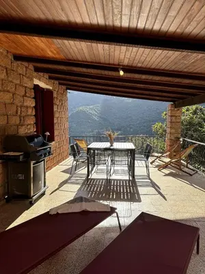 a table and chairs on a patio with a view at Résidence Hôtelière CASA DI BABBÒ, Porto in Porto Ota