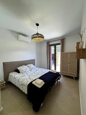 a bedroom with a bed and a chandelier at Résidence Hôtelière CASA DI BABBÒ, Porto in Porto Ota