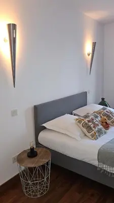 a bedroom with a bed and a table and lights at Maison de Maître Albitru - Domaine Romella - Piscine - Vue Golfe St-Florent in Vallecalle