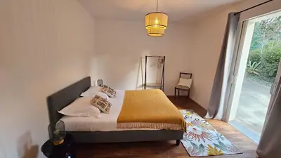 a bedroom with a bed and a large window at Maison de Maître Albitru - Domaine Romella - Piscine - Vue Golfe St-Florent in Vallecalle