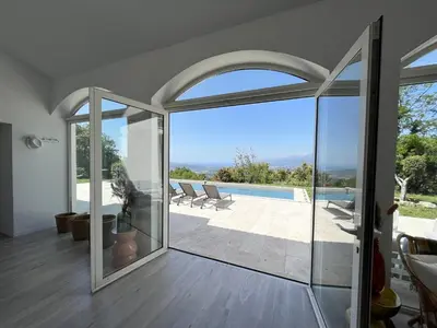 an open living room with a view of a pool at Maison de Maître Albitru - Domaine Romella - Piscine - Vue Golfe St-Florent in Vallecalle