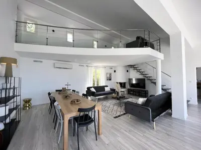 a living room with a dining table and a loft at Maison de Maître Albitru - Domaine Romella - Piscine - Vue Golfe St-Florent in Vallecalle