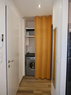 a laundry room with a washing machine and a curtain at Entre mer et montagne in Peri