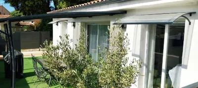 a white house with a window and an awning at Entre mer et montagne in Peri