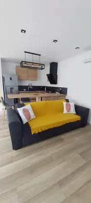 a yellow bed in a room with a desk at Entre mer et montagne in Peri