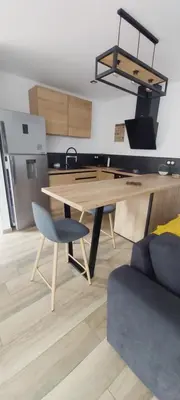 a kitchen with a wooden table and a chair at Entre mer et montagne in Peri