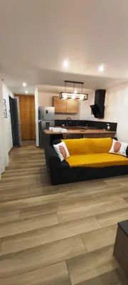 a bedroom with a yellow bed and wooden floors at Entre mer et montagne in Peri