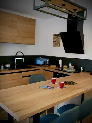 a kitchen with a wooden table and blue chairs at Entre mer et montagne in Peri