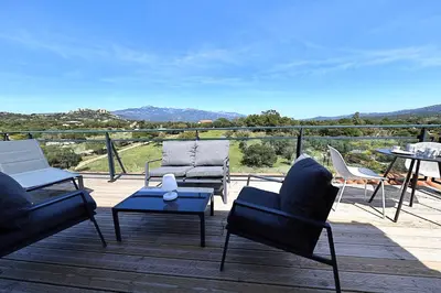 a patio with two chairs and a table on a deck at Superbe studio - Terrasse 360 avec vue mer in Pianottoli-Caldarello