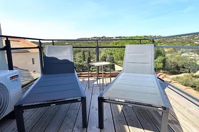 two chairs sitting on a deck with a table at Superbe studio - Terrasse 360 avec vue mer in Pianottoli-Caldarello