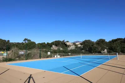 a tennis court with a net on top at Superbe studio - Terrasse 360 avec vue mer in Pianottoli-Caldarello