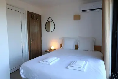 a bedroom with a white bed with two towels on it at Superbe studio - Terrasse 360 avec vue mer in Pianottoli-Caldarello