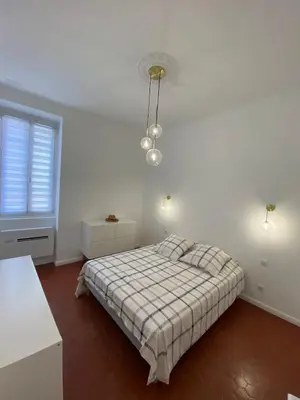 a white bedroom with a bed and a window at Grand T2 Cours Napoléon A in Ajaccio